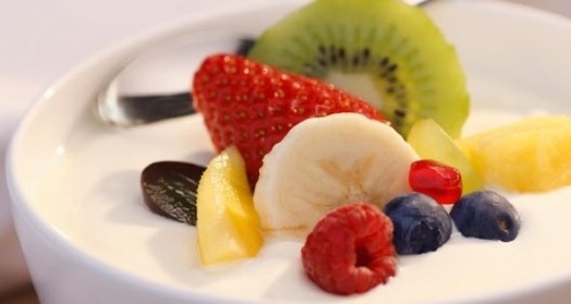 Домашний йогурт из закваски живой баланс в белой пиале с фруктами и ягодами с ложкой