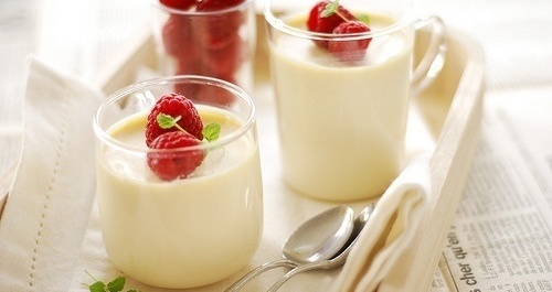 Вкусный домашний йогурт из закваски живой баланс в стаканах и чашках с малиной на салфетке и белом подносе с ложкой